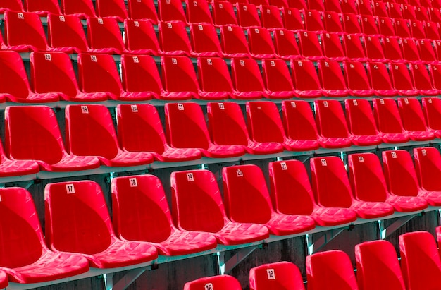 De gevouwen rode plastic stoelen op een tijdelijke tribune Selectieve focus