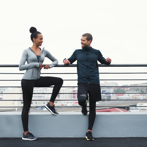 De gezondheidsvoordelen van regelmatige lichaamsbeweging zijn moeilijk te negeren Shot van een sportieve jonge man en vrouw die een pauze nemen tijdens het sporten in de buitenlucht