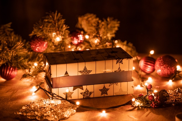 De giftvakjes van Kerstmis decoratie met Kerstboom en kaarslichten op de houten lijst met bokehlichten