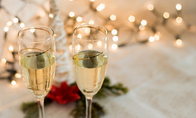 De glazen met champagnedetail met Kerstmis steken gouden achtergrond aan