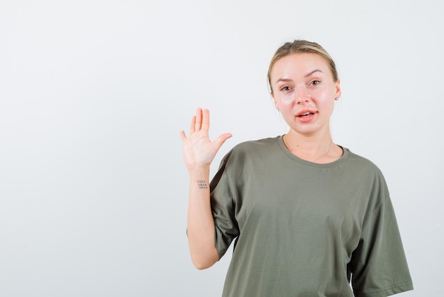 De glimlachende blonde vrouw toont stopgebaar met hand op witte achtergrond