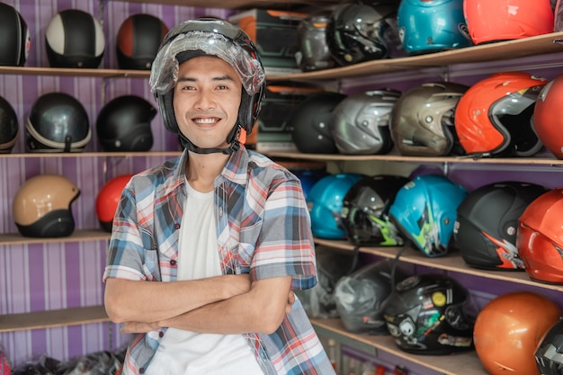 De glimlachende mens die helm met gekruiste draagt dient de achtergrond van het de rek van de helmvertoning in