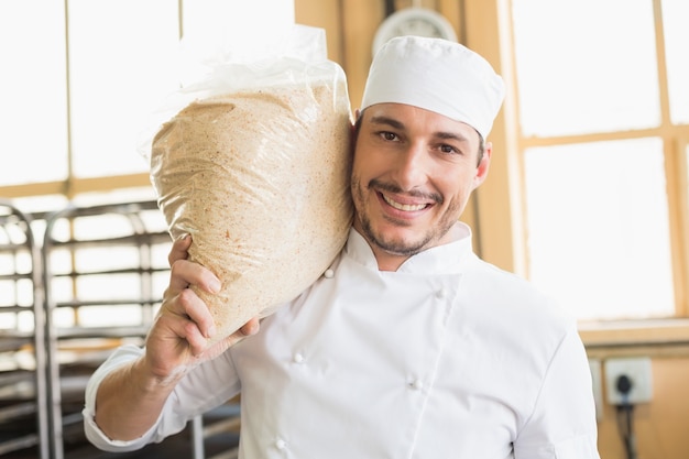 De glimlachende zak van de bakkersholding rijzend deeg