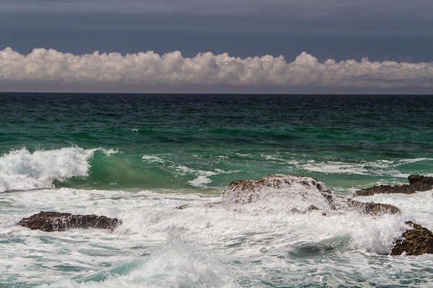 De golven die vechten om de verlaten rotskust van de Atlantische oceaan Portugal