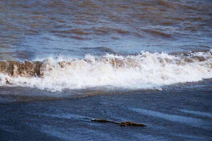 Foto de golven van de kust slaan tegen de zandkust.