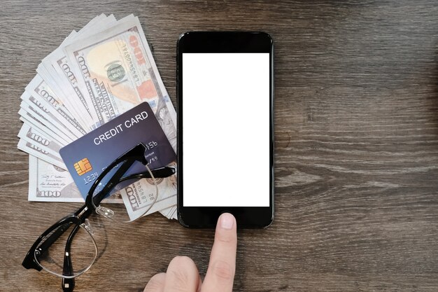 De greep lege smartphone van de vrouwenhand met creditcard en geld op de lijst in koffiewinkel