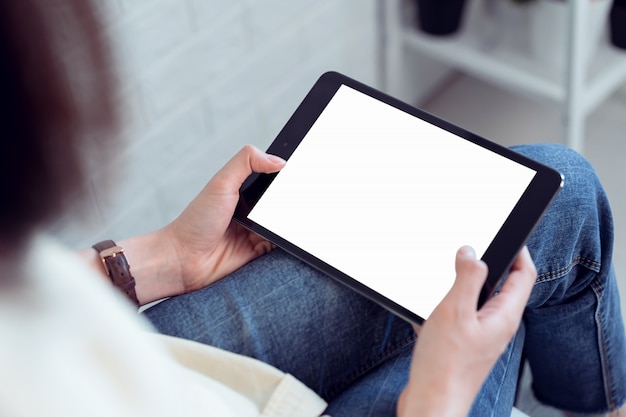 De greeptablet van de vrouwenhand en digitale pen met het lege exemplaar ruimtescherm. laptop op de tafel in het kantoor.