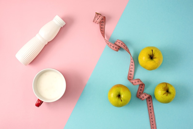 De groene appel en de fles yoghurt met meetlint. Concept van voeding en een gezonde levensstijl