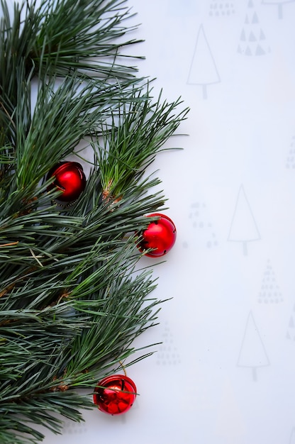 De groene takken van de den zijn versierd met rode ballen Kerstachtergrond en nieuwjaarskaart