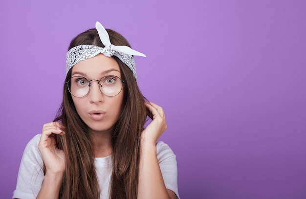 De groenogige bruinharige vrouw met een bril is verrast.