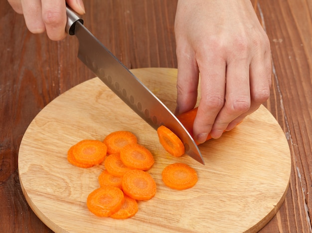 Foto de groenten snijden met een keukenmes op het bord