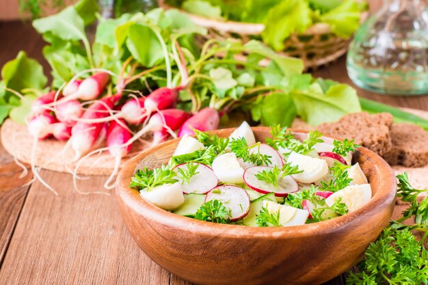 De groentesalade van de lente in een houten plaat