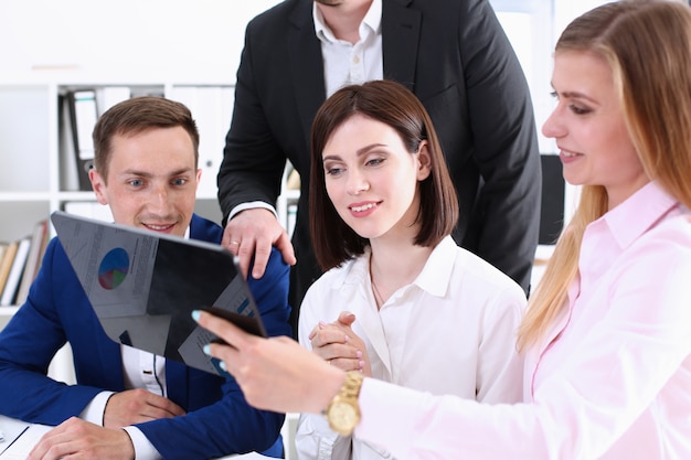 De groep mensen in bureau bekijkt mobiele tabletpc