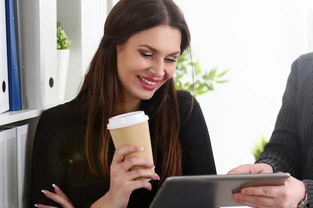 De groep mensen in bureau bekijkt mobiele tabletpc