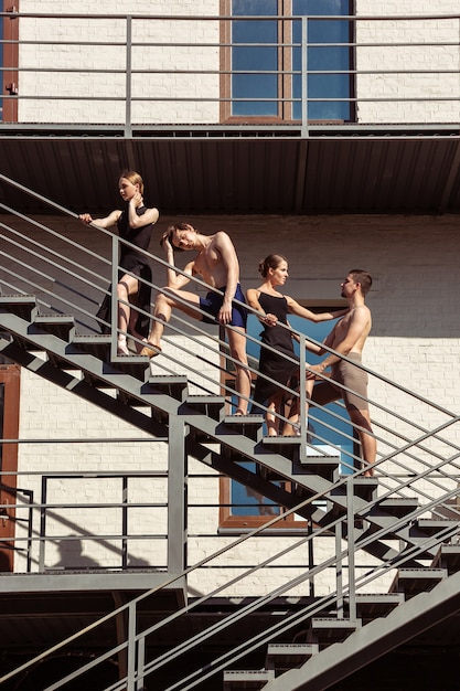 De groep moderne balletdansers die optreden op de trappen in de stad