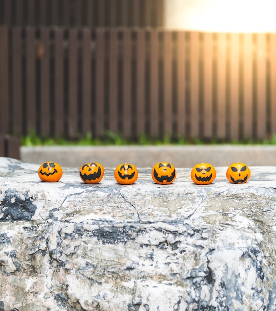De groep sinaasappelen ziet het schilderen met eng op Halloween-partijdag onder ogen op de tuinplaats.
