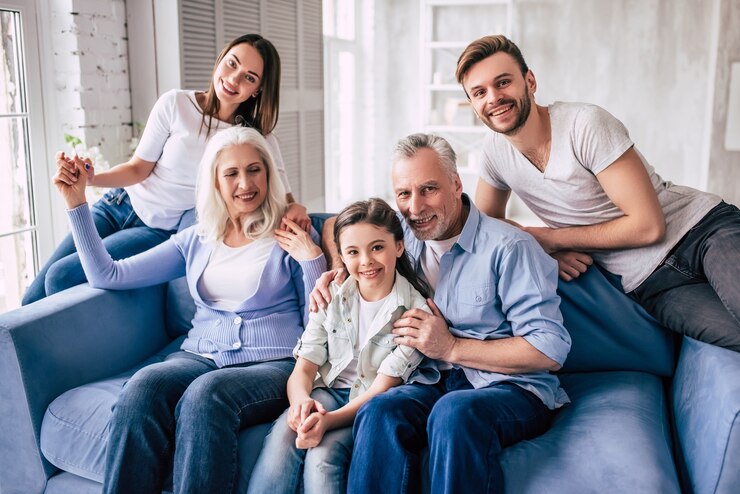 Foto de grote gelukkige familie zit op de bank