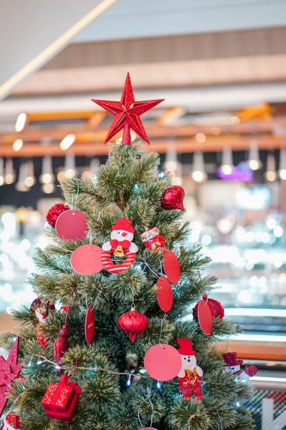 De grote rode sterdecoratie bovenop de kerstboom.