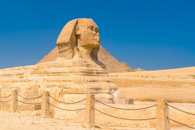 De Grote Sfinx van Gizeh en op de achtergrond de piramides van Gizeh op een zomermiddag, het oudste grafmonument ter wereld. In de stad Caïro, Egypte