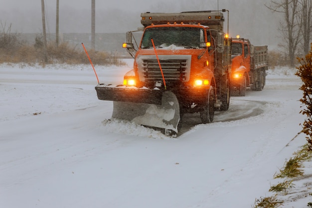 De grote sneeuwstraat van de tractorverwijdering tijdens sneeuwblizzard
