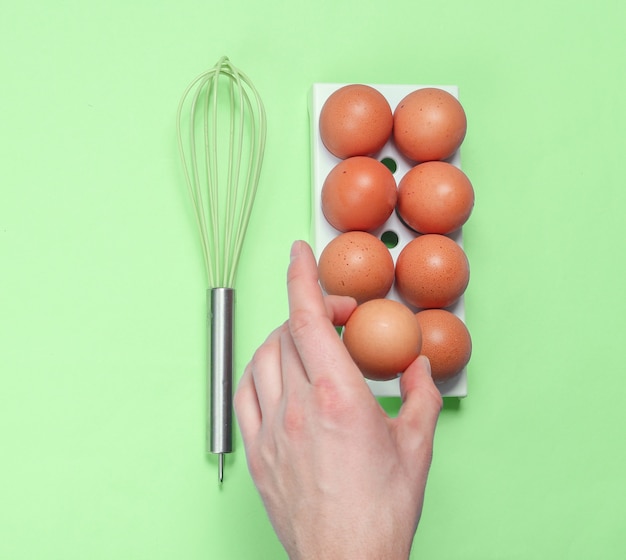 De hand die van de vrouw ei neemt van het culinaire concept van het eierblad