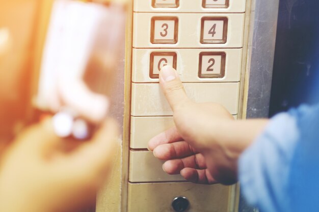 De hand drukt op de oude liftknop