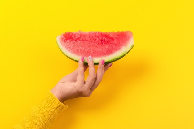 De hand houdt watermeloenplak