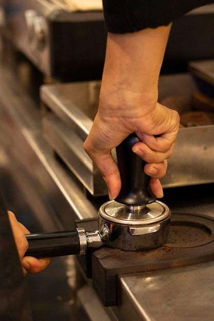 De hand maalt de koffiebonen met een molen. Barista maakt koffie met een machine. toonbank van coffeeshop.