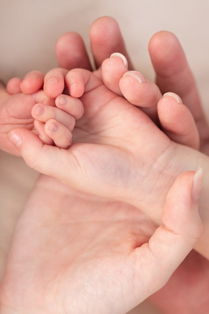 De hand van de baby is in handen van de ouders