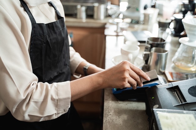 De hand van de kassier veegt met een creditcard