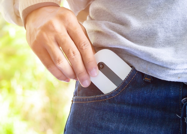 Foto de hand van de mens zette een zakwifi in zijn jeanszak