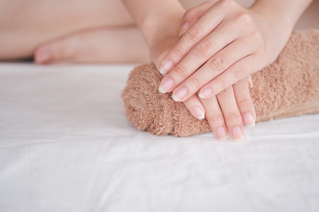 De hand van de vrouw wordt op de rolhanddoek geplaatst, concept van gezondheidszorg van de vingernagel.