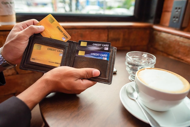 Foto de hand van de zakenman pakt zijn creditcard uit zijn portemonnee