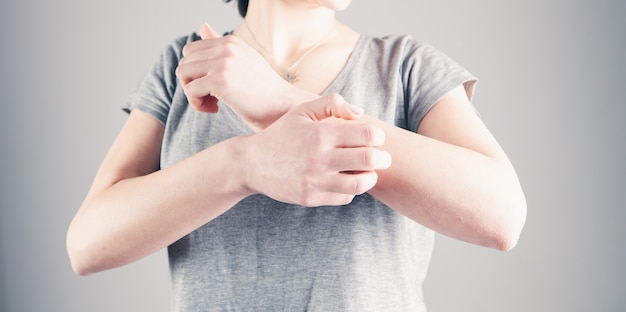 De hand van een jonge vrouw jeukt