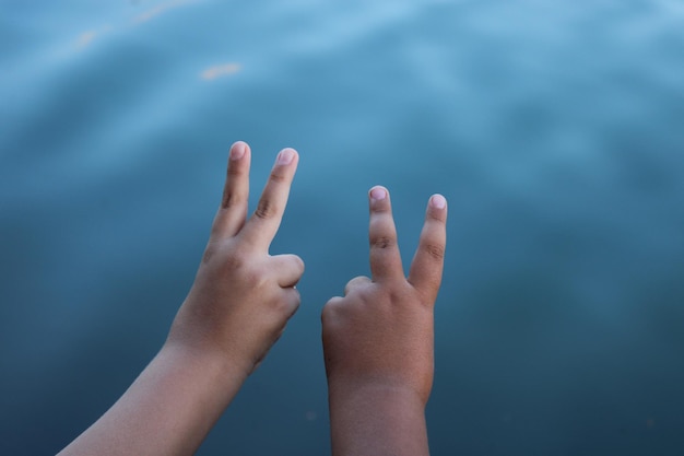 De hand van een kind ligt in het water met de letter v erop.