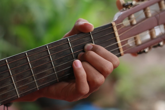 de hand van een man met gitaar en muziek