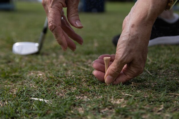 De hand van een oudere vrouw slaat af op de golfbaan