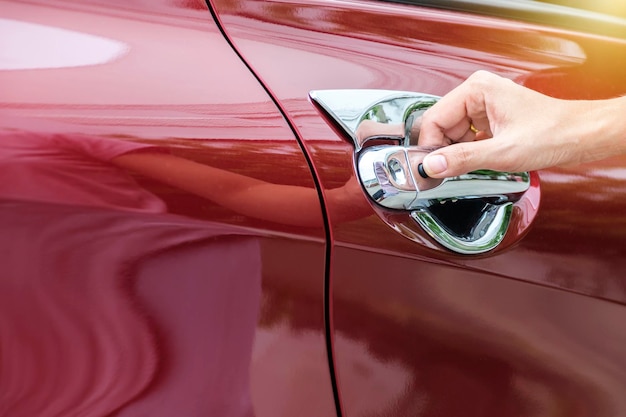 De hand van een vrouw die een autodeur openhoudt Close-up beeld van een vrouw opent de autodeur