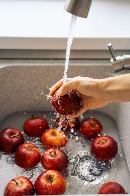 Foto de hand van een vrouw wast de appels