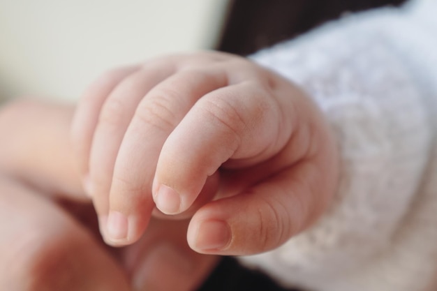 De hand van het kind houdt de vinger van de moeder vast. Familie scène. Ondiepe scherptediepte