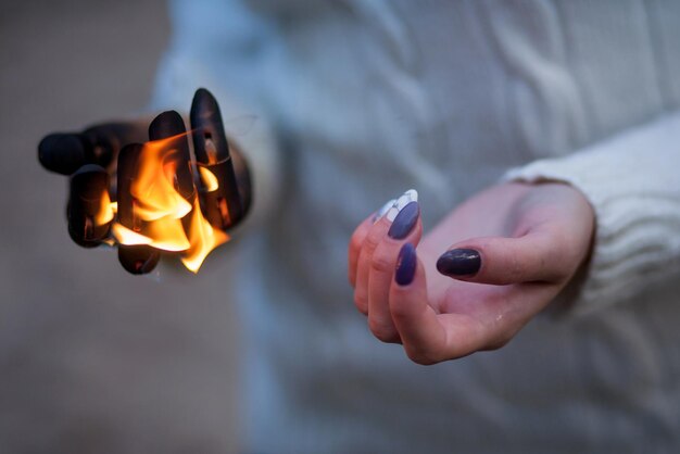 De hand van het meisje tegen het vuur. Brandende hand. Helder symbool Flamy. Vuur in de hand.