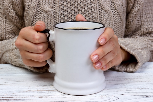 De handen die van de vrouw kop met koffie, hoogste mening houden