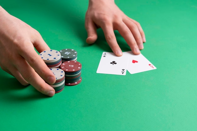 De handen nemen de casino pokerfiches op de groene tafel, gokken en geluk concept