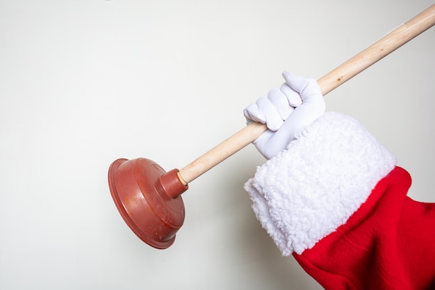 De handen van de kerstman met een toiletplunjer