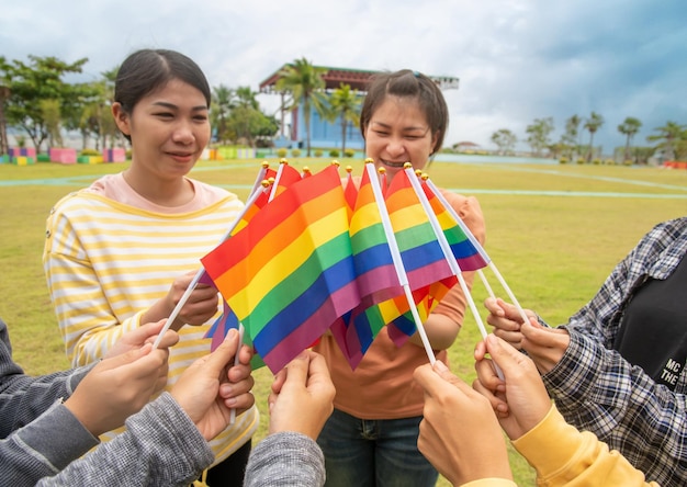 De handen van diversiteitsmensen die kleurrijke lgbtq-regenboogvlaggen samen opheffen een symbool voor de lgbt-gemeenschap