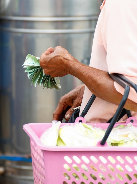 Foto de handen van een bejaarde vrouw houden geld vast