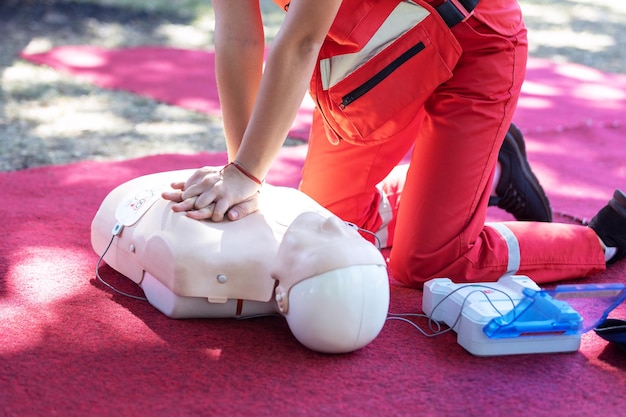 Foto de handen van een hulpverlener die borstcompressie doet tijdens de training voor cpr met een defibrillator