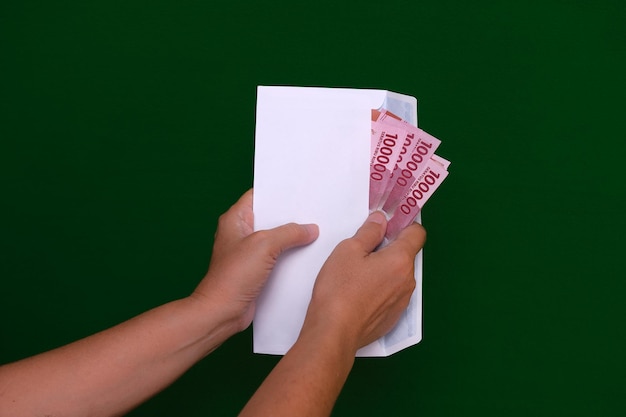 Foto de handen van een vrouw halen wat geld uit een witte envelop