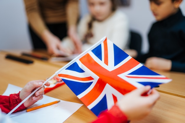 De handen van het kind houden de Engelse vlag vast