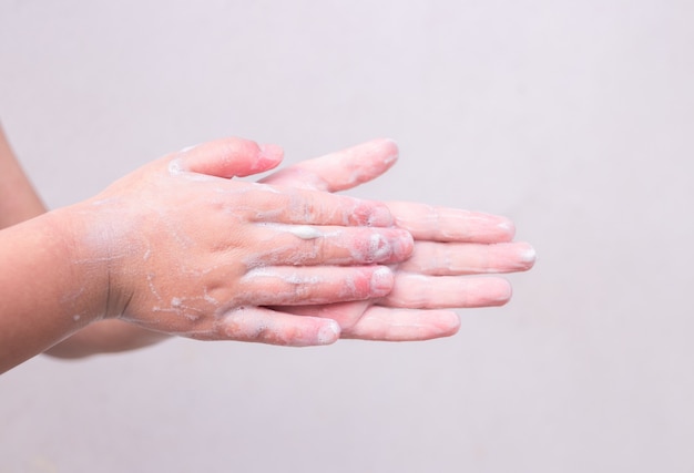 De handen van het kind wassen hun handen. Persoonlijke hygiëne, handen reinigen.